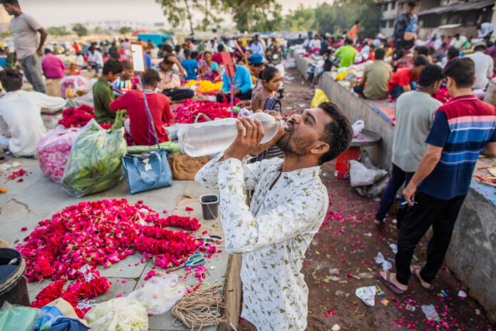 Person drinking water in ahmedabad market